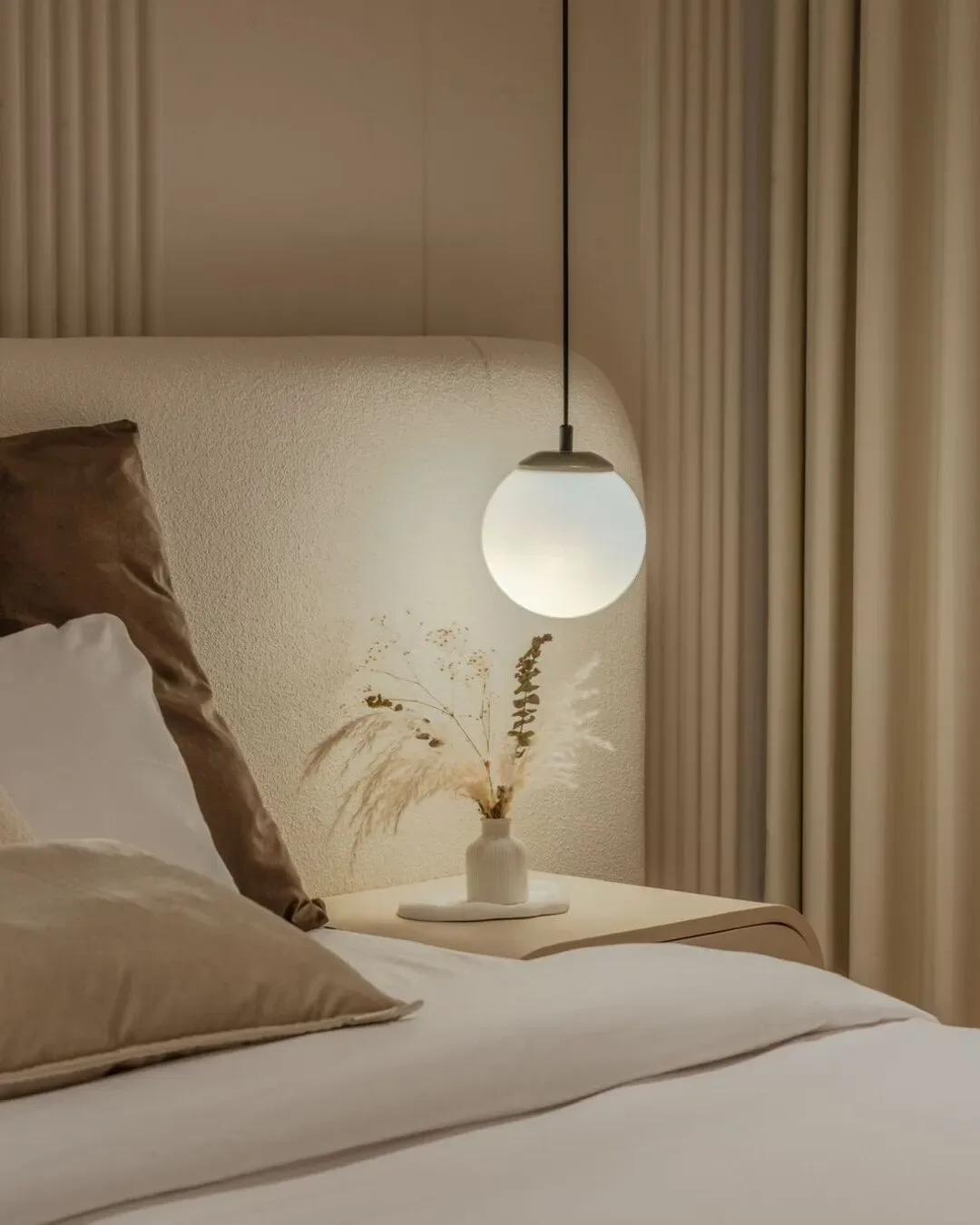 Dormitorio cálido con iluminación envolvente, texturas suaves y detalles refinados