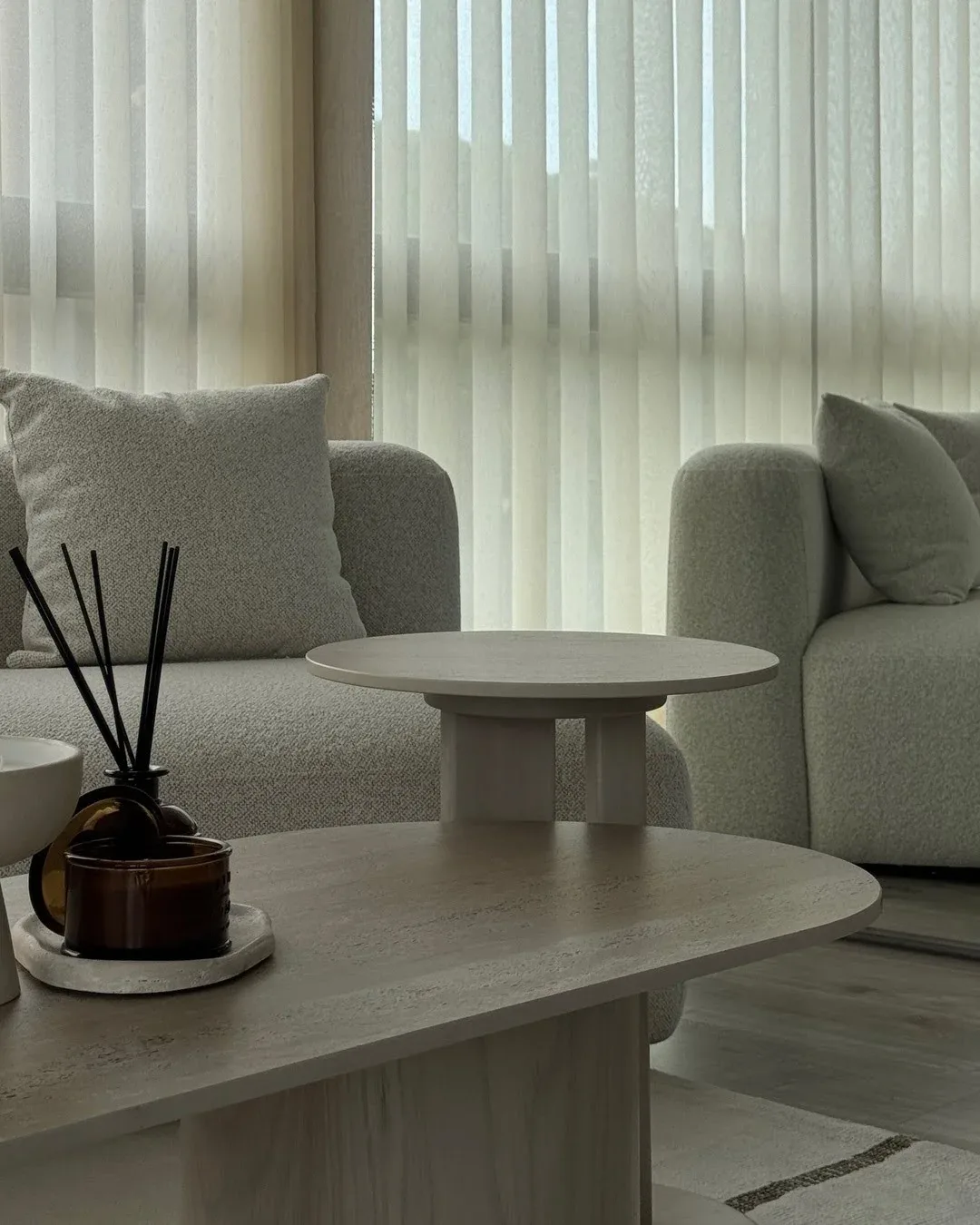 Sala de estar luminosa con un gran sofá modular texturizado y un espejo de cuerpo entero.