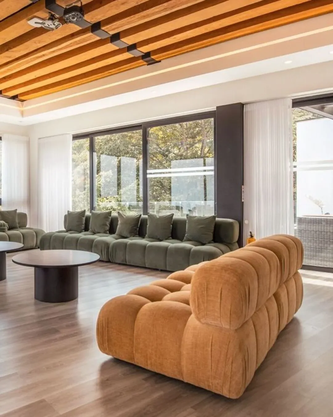 Sala campestre con sofá voluminoso, texturas acogedoras y conexión natural.