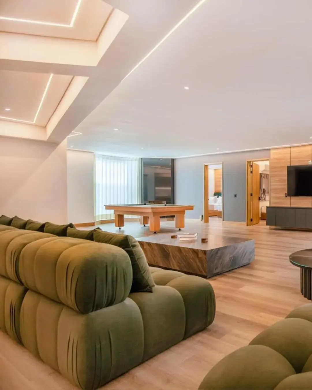 Sala hotelera amplia con sofás voluminosos, luz cálida y zonas pensadas para permanecer.