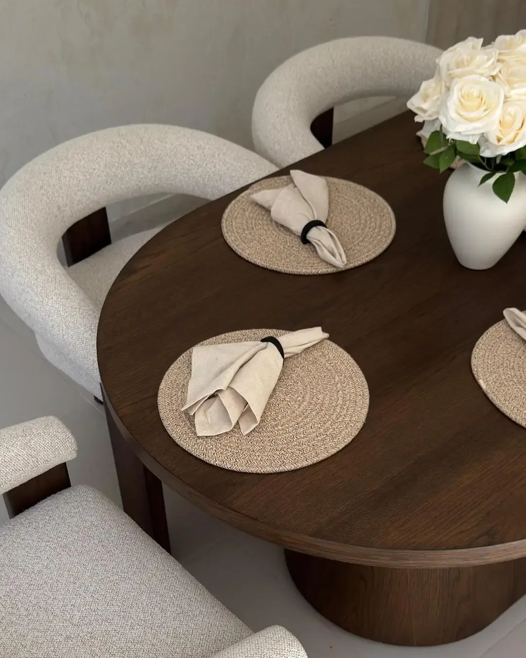 Organic dining table with upholstered chairs, neutral tones, and handcrafted details.