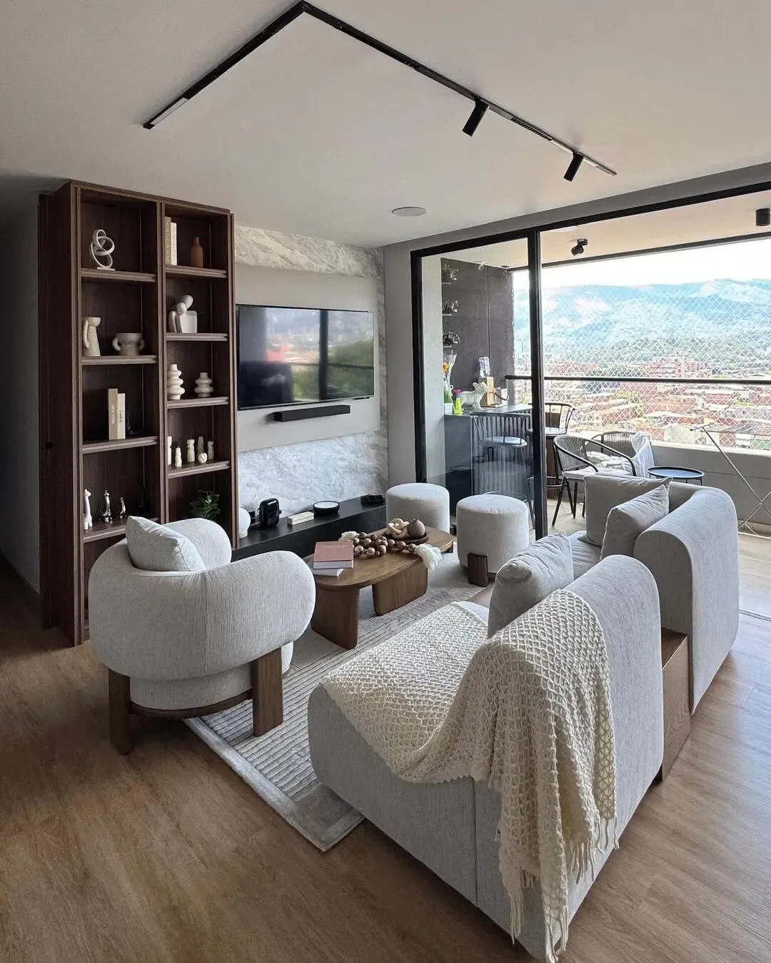 Sala y comedor integrados con mobiliario compacto, madera cálida y circulación bien resuelta.