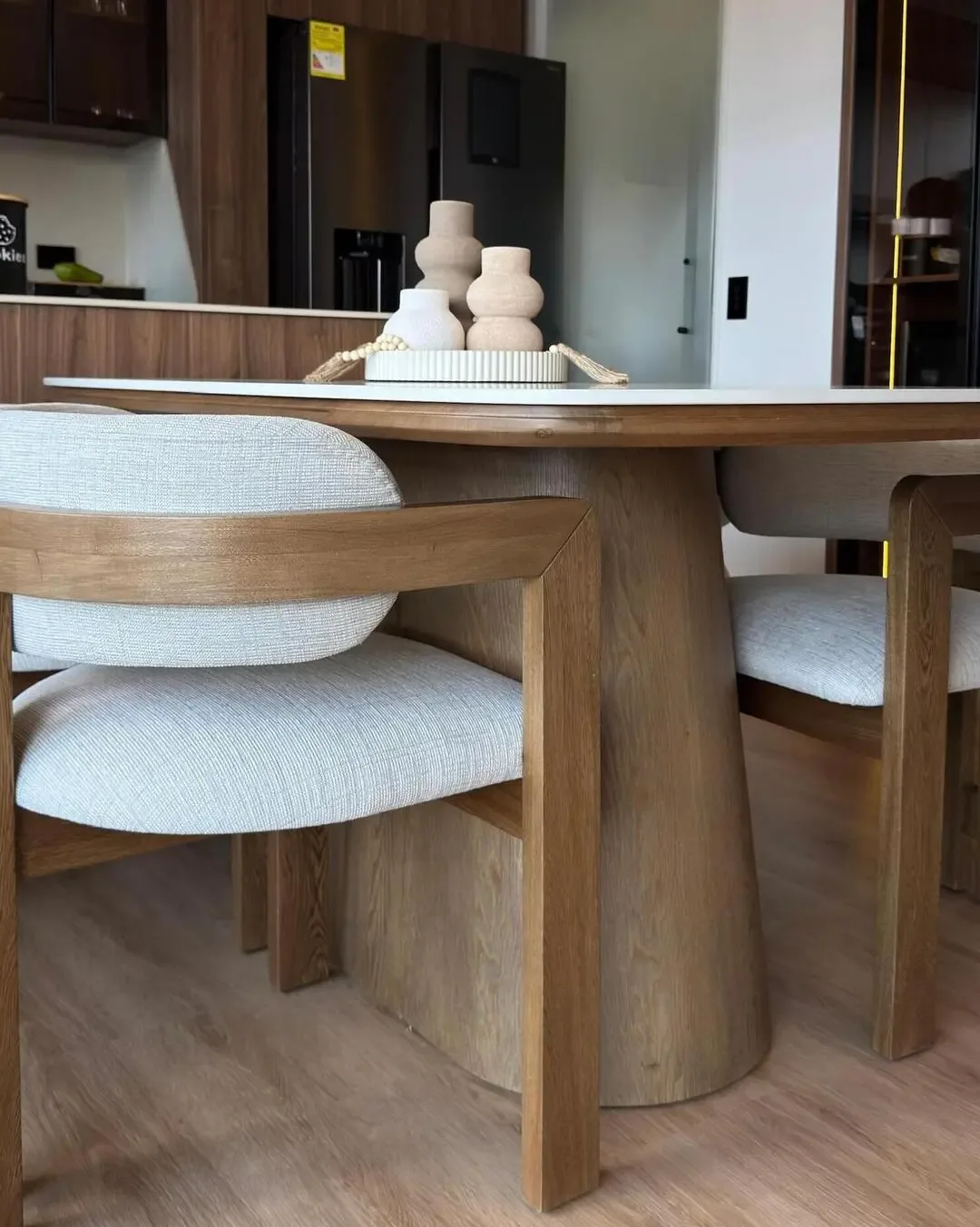 Comedor compacto con sillas tapizadas, madera cálida y diseño pensado para circular.