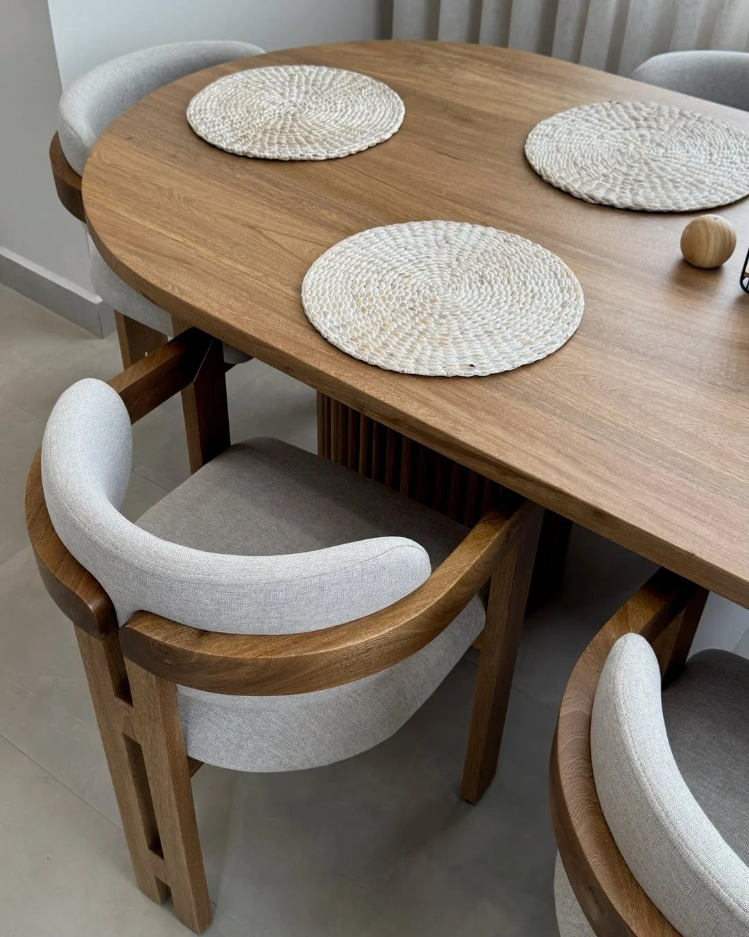 Vista en perspectiva de una mesa de comedor ovalada con sillas de diseño contemporáneo.